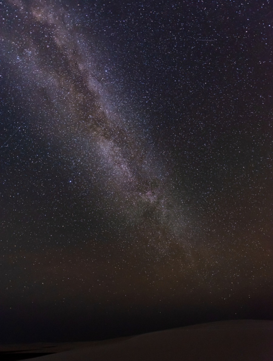 A Via Láctea sobre a crista de uma duna, céu cheio de estrelas