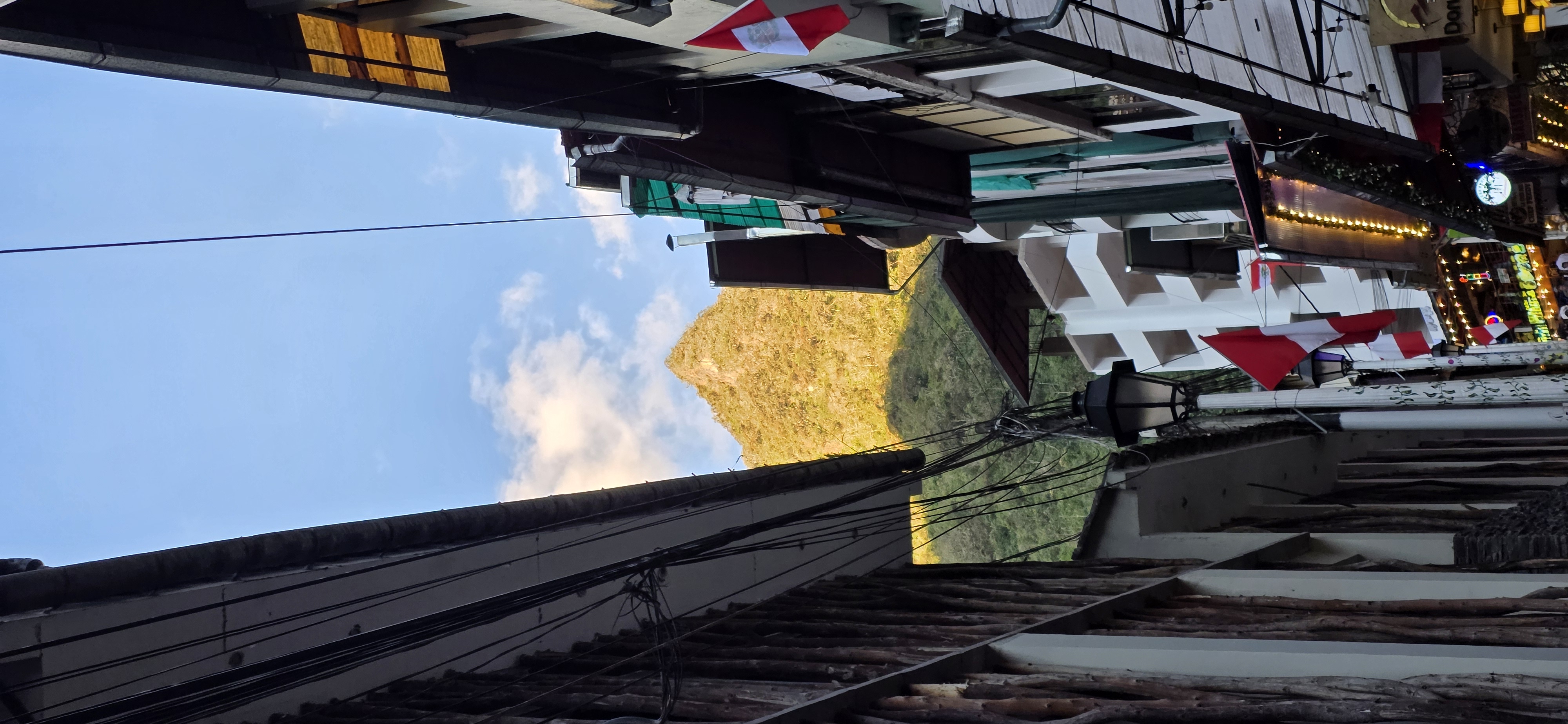 A mesma rua ao anoitecer, com o morro ainda aceso pelo sol