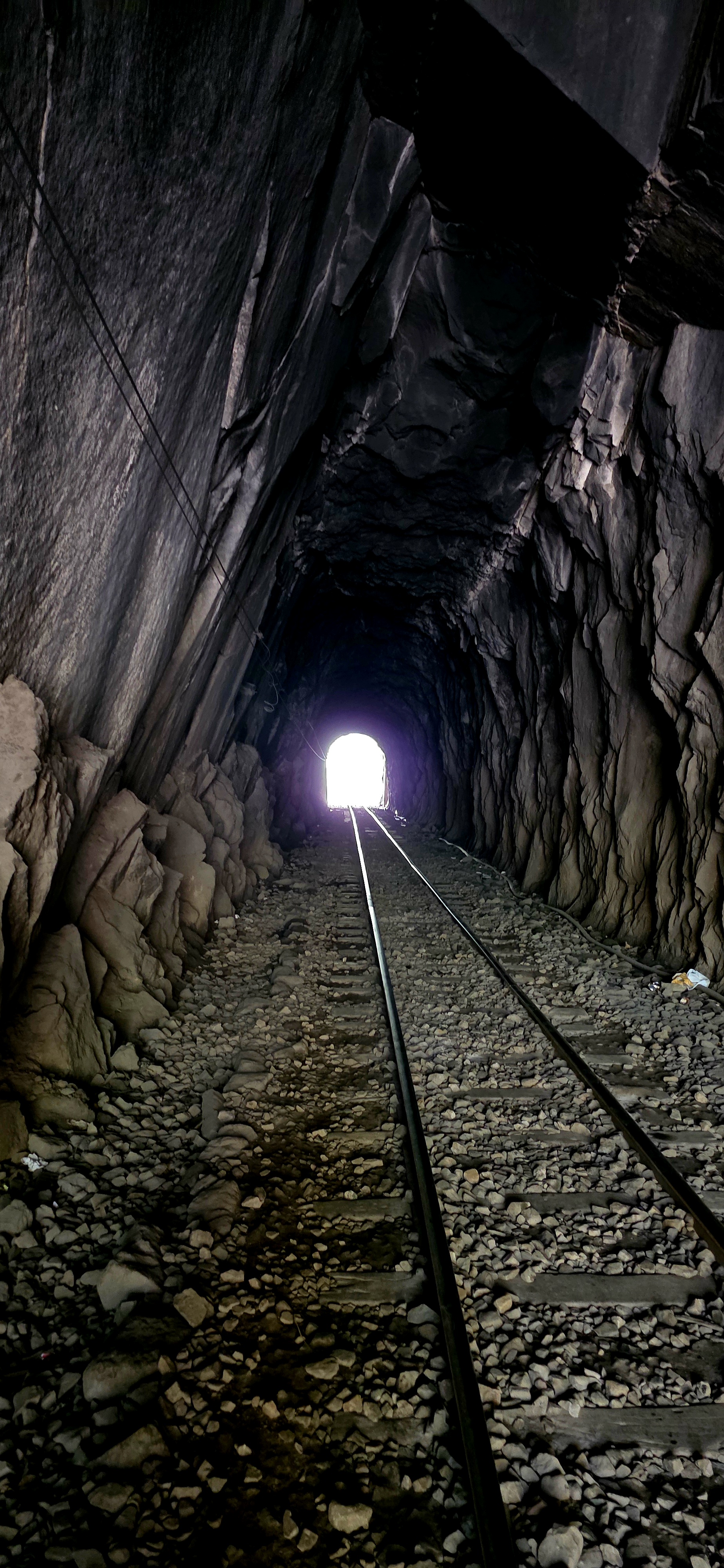 O túnel ferroviário no caminho para Mandor: trilho, brita e a luz no fim